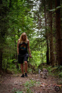 DOGS Hundetrainerin Lisa Pursch geht in sommerlicher Kleidung mit ihrem Chihuahua durch den Wald