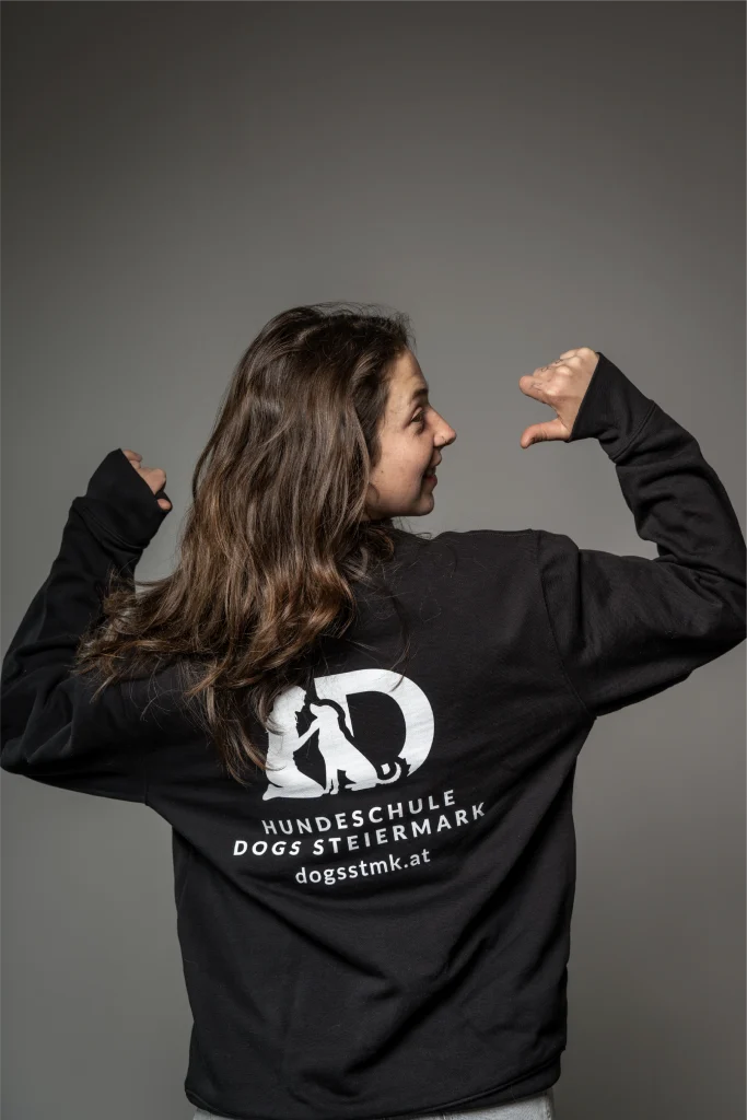 Trainerin mit schwarzem Pulli mit Hundeschule Logo