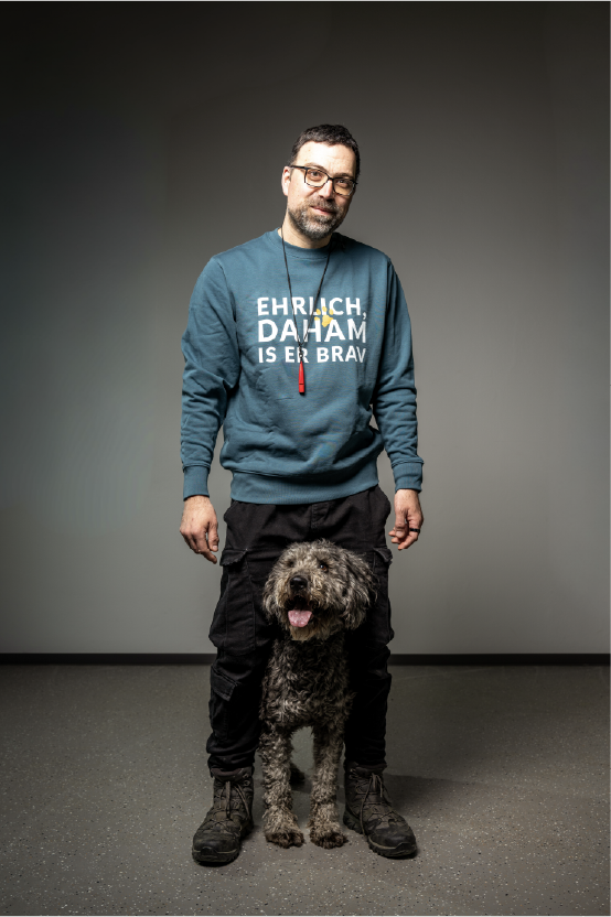 Hundetrainer der Hundeschule Graz im blauen DOGS Steiermark Pullover